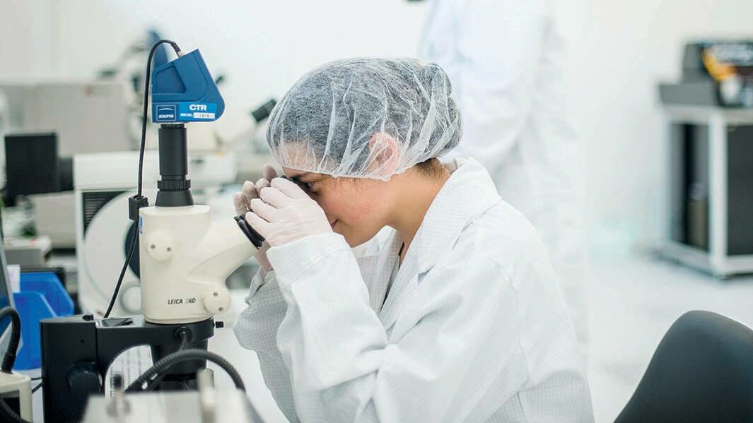 Researchers work on the microscope in the clean room