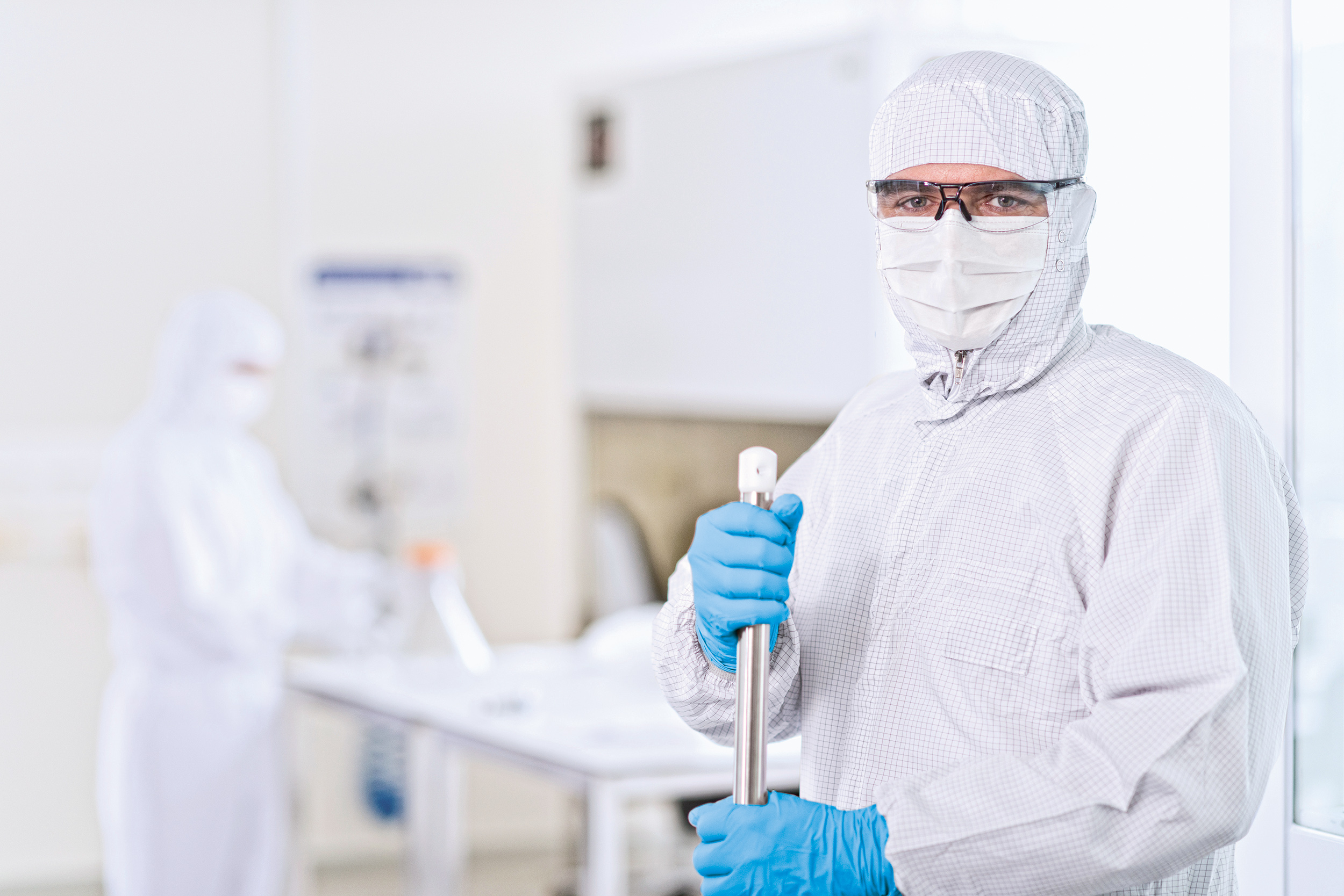 An employee wears a protective suit to work in the cleanroom