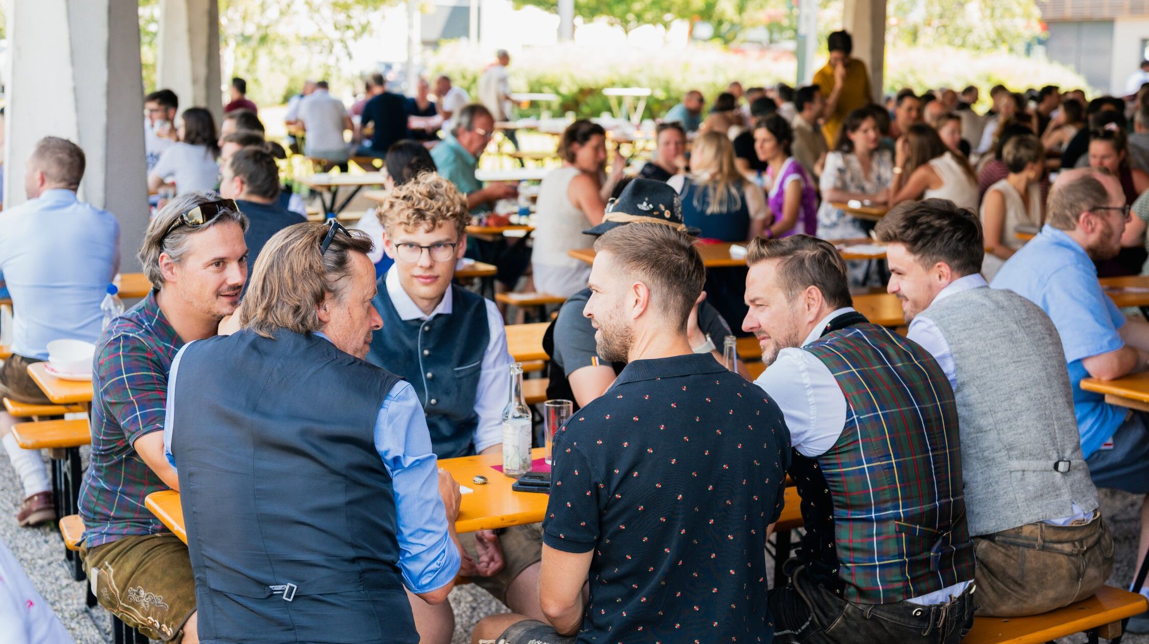 Ausgelassenes Feiern beim Technologiepark Villach Kirchtag Gäste des Technologiepark Kirchtags sitzen in Tracht gemütlich zusammen