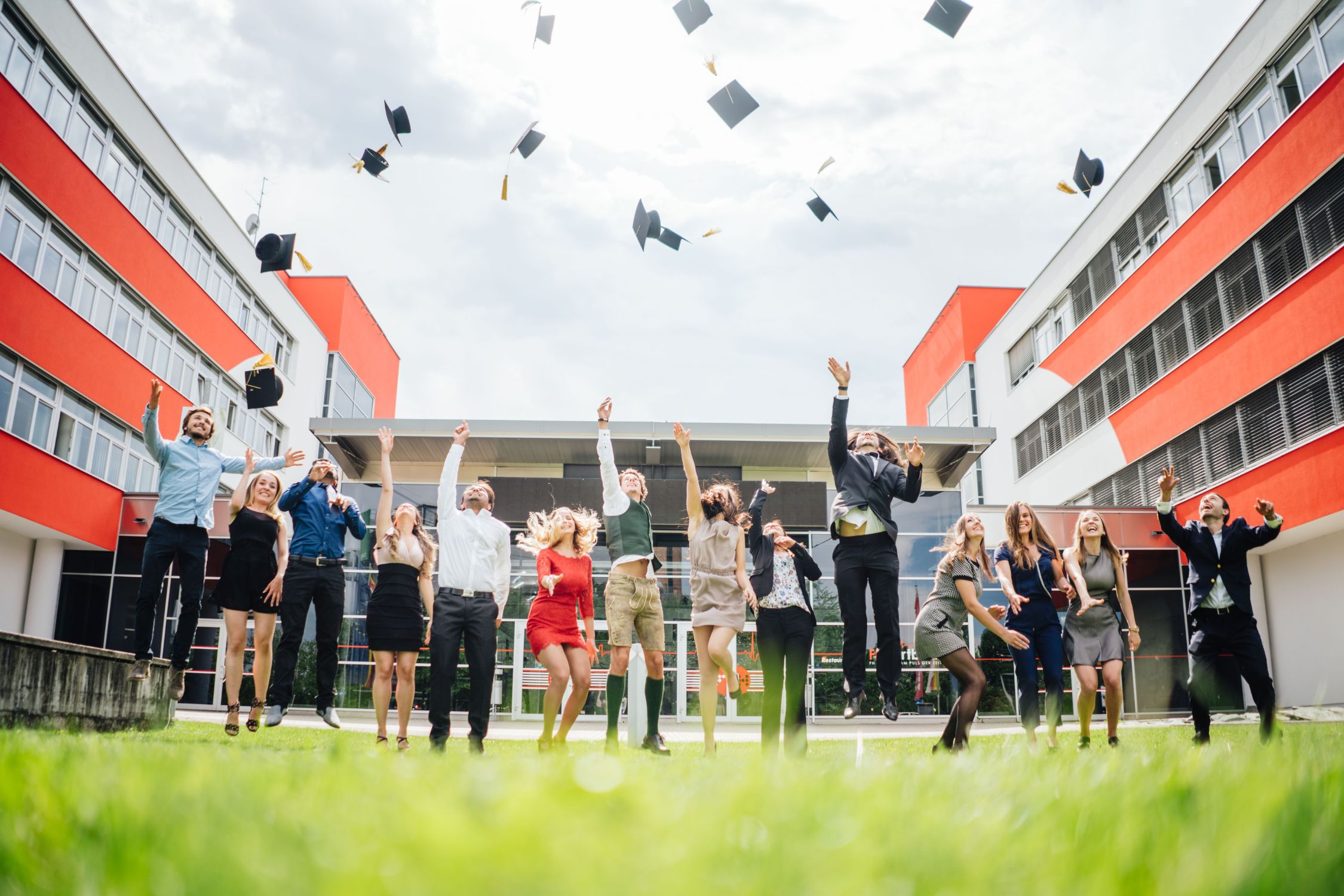 Studierende werfen ihre Absolventenhüte in die Luft