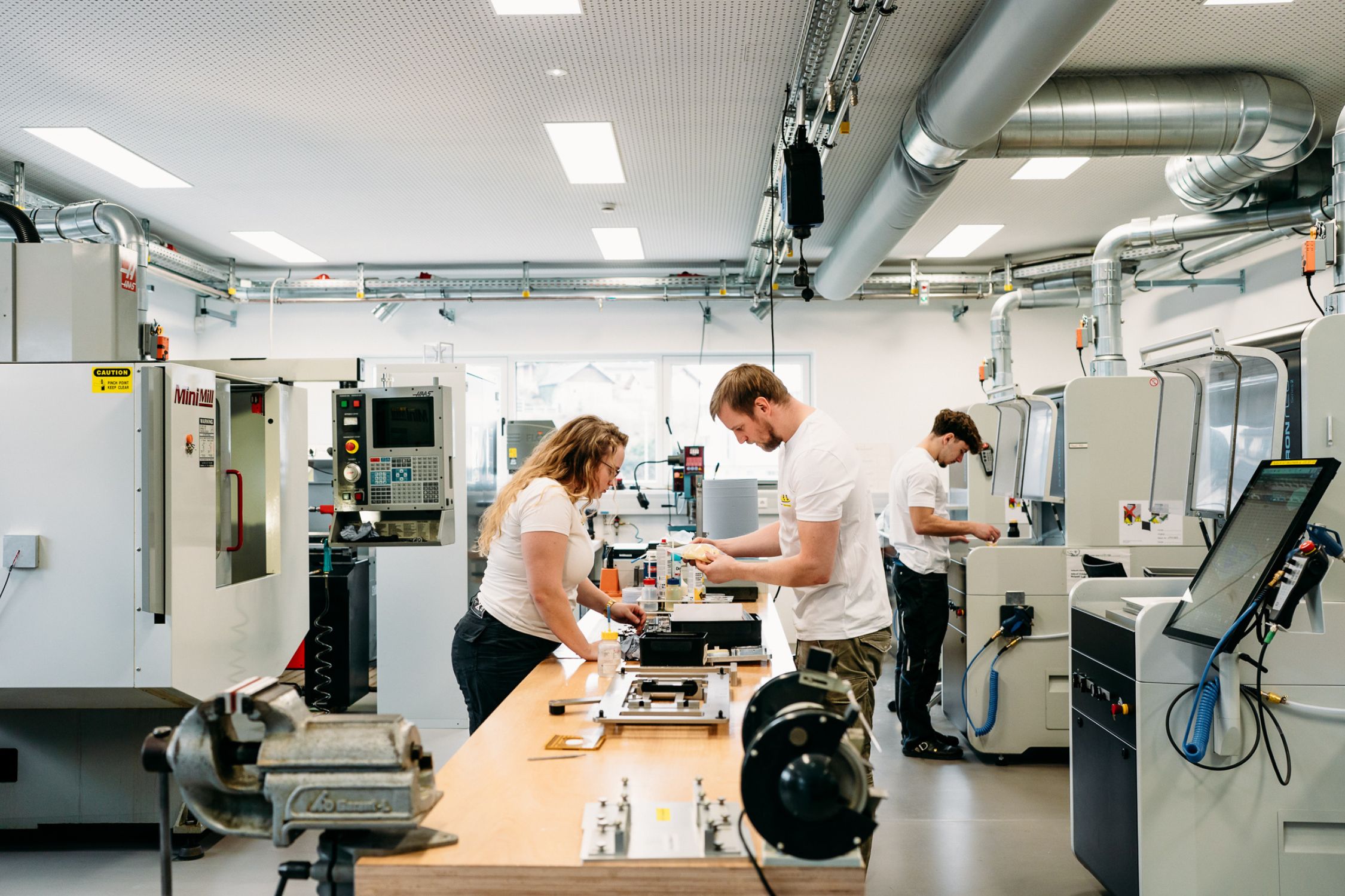 Three employees of T.I.P.S. working in a production room
